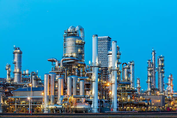 A large, modern petrochemical plant at dusk in industrial district near Rotterdam, Netherlands, Benelux, Europe. Distillation towers and other installations are visible against blue sky. 50 megapixel image taken with Canon EOS 5Ds, digital blending technique, long exposure with tripod.